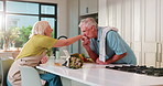 Old couple, kiss and dancing in kitchen with love, bonding and celebration for anniversary in home. People, senior man and woman excited for cooking, bouquet or flowers for relationship at house
