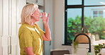 Drinking, water and woman in kitchen, thirsty and wellness with nutrition, refresh and detox in home. Healthy, hydration and mature person with liquid for digestion, diet and minerals in apartment