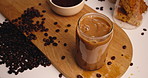 Above, coffee or hands in home with ice cube, splash or caffeine boost in morning drink. Explosion, hydration or person in house with ground beans, antioxidant or heart health in breakfast beverage.