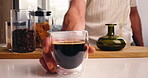 Espresso, coffee and hands of person in kitchen of home for morning drink, caffeine and latte. Cappuccino, liquid and brewing beans with man and cup of beverage in apartment for mocha and roast