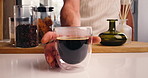 Hands, man and cup of coffee in kitchen for morning beverage, brewing and cappuccino liquid. Espresso shot, drink or latte with person to start day, cafe mocha and roast with strong caffeine at house
