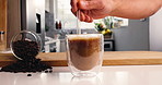 Straw, coffee and hands of person in kitchen of home for morning beverage, brewing or cappuccino liquid. Espresso shot, drink and cup of latte with man in apartment for cafe mocha, roast and caffeine