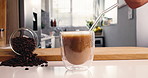 Milk, coffee and hands of person in kitchen of home for morning beverage, brewing or cappuccino liquid. Espresso shot, drink and cup of latte with man in apartment for cafe mocha, roast and caffeine