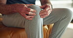 Hands, senior man and knee pain in home with arthritis, muscle tension and fibromyalgia risk. Retirement, elderly person and leg massage on sofa for inflammation, torn ligament and cartilage sprain