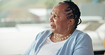 Thinking, window and senior black woman in home for thoughtful, wondering and nostalgia in house. Retirement, dementia and mature person lonely in living room with sadness, memory and reflection