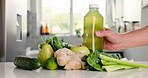 Green, ingredients and hands with juice on kitchen counter, detox or healthy drink for wellness benefits. Nutrition, gut health or person in home with bottle for liquid, fruits and vegetable for diet