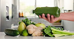 Green, ingredients and hand shake bottle in kitchen, detox and healthy drink for wellness benefits. Nutrition, gut health and person in home with juice container, raw fruits and vegetable for diet.
