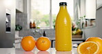 Nutrition, juice or bottle in kitchen with orange, antioxidant or vitamin benefit in morning drink. Organic, hydration or fruit in home with detox diet, gut health or digestion in breakfast beverage.