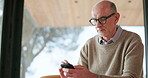 Typing, social media or elderly man on sofa with phone, chat or news update on multimedia network. Digital, scroll or senior person in home with tech, online texting or internet search on mobile app.