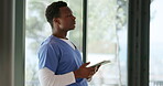 Surgeon, stress and black man with tablet by window, research protocol or procedure info for operation. Theater doctor, worry or read with tech in hospital, medical education and learn for healthcare