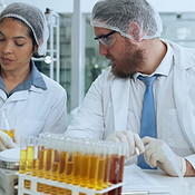 Scientist, team or planning in laboratory with beaker for research ...