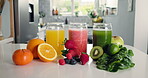 Wellness, fruit and glass of juice in kitchen for detox, antioxidants or vegan drink. Gut health, nutrition and vegetables with organic liquid on table top of home for diet, breakfast and weight loss