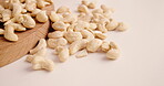 Healthy, cashew and nuts on board in studio with natural textures, organic food and grain production. Seeds, products and roasted for harvesting season, quality control and vegan snack with nutrition