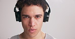 Exercise, headphones and face of man in studio with playlist for workout, training and fitness routine. Sports, breathe and portrait of person listening to audio, music or podcast on white background