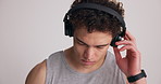 Fitness, serious and man in studio with headphones for workout, training and exercise routine. Sports, space and person listening to audio, music and podcast for motivation on white background