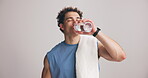 Thirsty, man and drinking water for fitness in studio for dehydration, refreshing and exercise break. Mockup space, person and bottle with liquid for training recovery, exhausted and white background
