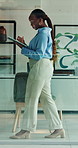 Black woman, walking or typing on tablet for business, green NGO or project management with thinking. Sustainable company, employee or tech in glass office with pacing, research or scroll on platform