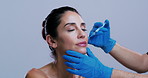 Mature woman, hands and lip filler in studio for dermatology, injection and mock up space on background. Person, surgeon and gloves with syringe for beauty, cosmetic procedure and transformation