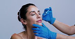 Woman, face and syringe for lip filler in studio with gloves, procedure or mockup space on background. Person, doctor and needle with plastic surgery, dermatology or process for beauty transformation