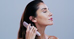Brushing, hair and woman in studio, haircare and detangling knots with tool, confident and grooming. Hairstyle, growth or mature person with equipment for healthy texture, routine and blue background