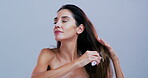 Grooming, woman and brush in studio, haircare and detangling hair with tool, self care or confident. Hairstyle, routine and mature person with equipment for healthy texture, growth or blue background