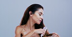 Self care, woman and brush in studio, haircare and detangling hair with tool, grooming or confident. Hairstyle, routine and mature person with equipment for healthy texture, growth or blue background
