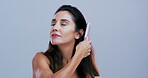 Brushing, hair and woman in studio, confident and detangling knots with tool, haircare and grooming. Hairstyle, self care and mature person with healthy texture, mockup space and blue background