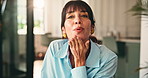Face, happy woman and blow kiss in home for love, care and laughing with affection emoji. Portrait, mature person and gesture for romance, funny and sign for flirting with smile in living room