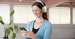 Smartphone, headphones and woman in studio, fitness and listening to music, radio and wellness. Healthy, cellphone and happy person with exercise, podcast and audio with sound, digital app or workout