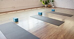 Fitness, yoga and mat in studio on floor, preparation and equipment for body wellness class. Start, empty room and setup in gym with support blocks, workout group or beginning of pilates training.