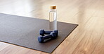 Yoga mat, dumbbells and water bottle in studio for fitness challenge, hydration or sports workout. Kneeling pad, weights or drink in health club for exercise, physical activity or liquid electrolytes