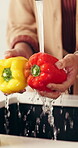 Hands, cleaning and vegetables in kitchen with water for meal prep, fresh food and healthy nutrition. Person, bell pepper and washing for dirt removal, bacteria prevention or cooking hygiene in home.