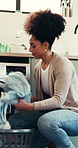 Kitchen, washing machine and woman with clothes, spring cleaning and chores in apartment and laundry. Sanitary, routine and loading fabric in electrical appliance, African person and hygiene in house