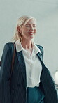 Walking, greeting and senior woman in office with smile, entry and motivated for start of day. Welcome, happy and female manager in workplace lobby with confidence, ambitious and friendly in morning.