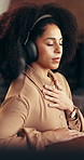 African woman, headphones and meditation in home for streaming podcast, breathing and mindfulness. Female person, stress relief and calm audio of zen practice, holistic balance and wellness technique