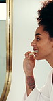 Woman, brushing teeth and mirror in bathroom with oral hygiene for cleaning mouth in morning. African person, toothbrush and reflection for dental care routine, wellness or plaque removal in house