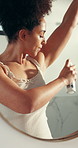 Mirror, woman and spray deodorant in bathroom for morning routine, odor control and fresh fragrance. Reflection, african person and armpit antiperspirant in home for underarm hygiene or getting ready