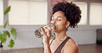 Fitness break, woman and drinking water at health club for hydration, exercise recovery and thinking. Happy, person and liquid bottle in studio for workout refresh, thirsty and rest from yoga routine