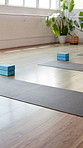 Yoga, empty and mat in studio on floor for workout routine, exercise and fitness class. Background, health club and room with equipment, blocks and gear for wellness, pilates lesson and session
