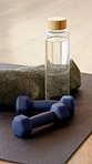 Yoga, empty and weights in studio on floor for workout routine, exercise and fitness class. Background, health club and equipment, water bottle and dumbbells on mat for wellness, pilates and gym