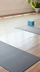Yoga, empty and mat in gym on floor for workout routine, exercise and fitness class. Background, health club and studio with equipment, blocks and gear for wellness, pilates lesson and training