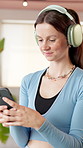 Phone, yoga and woman with headphones in studio for health app, music and exercise playlist. Gym, happy and person on smartphone listening to audio, radio and song in pilates class for wellness