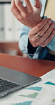 Hands, laptop and paperwork with wrist pain at desk, person typing for data entry and tension from overwork. Injury, carpal tunnel or fibromyalgia with analyst with graph or chart document with hurt