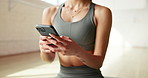 Hands, cellphone and woman in studio, fitness and typing with social media, internet and texting. Health club, mobile user and person with smartphone, exercise and message to contact and connection