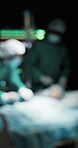 Medical, surgery and people in hospital with patient, support and operation in dark room. Healthcare, bokeh and doctor in theatre with procedure, medic teamwork and emergency service with blur.