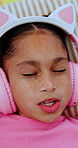 Singing, headphones and top view of child in bed at home for streaming service, sound or radio. Above, girl and kid listening to audio, song or dance to music playlist in bedroom to relax with face