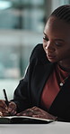 Finance, planning and writing with business black woman in office for accounting or schedule. Agenda, notebook and pen with African employee in financial workplace for banking, budget or development