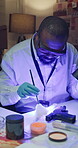 Brush, evidence and uv light with black man in police station for investigation, suspect analysis or process. Murder weapon, forensic pathology and dna profiling with person for fingerprints research