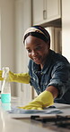 Cleaning, cloth and spray bottle with black woman in kitchen of home for chores or housework. Detergent, rag and wipe with happy African person in apartment to remove bacteria or germs for hygiene