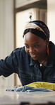 Black woman, cleaning and wipe counter at house for hygiene, surface disinfection and housekeeping. Smile, person and cloth with detergent for dust removal, prevent bacteria and household maintenance